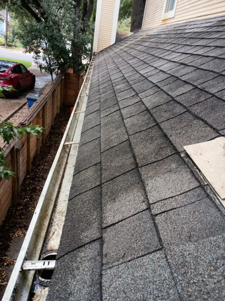 Professional gutter cleaning service in Austin, TX, showing a clean gutter and roof line